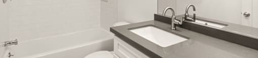 A white bathroom with a toilet, sink, and bathtub.