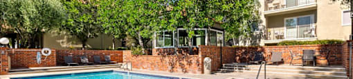 Encino, CA Apartments- Brookside Terrace Apartments- Sparkling Pool with Lounge Chairs and Scenic View of Outdoor Landscaping