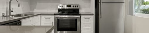 a kitchen with white cabinets and stainless steel appliances