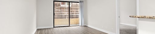 an empty living room with a patio door at Woodland Trio Apartments, North Hollywood, CA