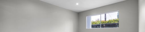 a bedroom with gray walls and a window