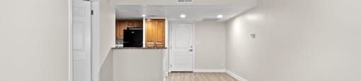 an empty living room with a kitchen in the background at Woodland Trio Apartments, North Hollywood, CA, 91601