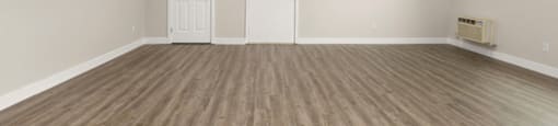 a bedroom with a hardwood floor and white walls