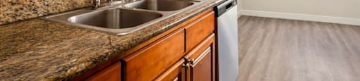 A kitchen with a granite countertop and wooden cabinets.