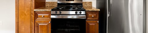 A kitchen with a stove, oven, microwave, and refrigerator.