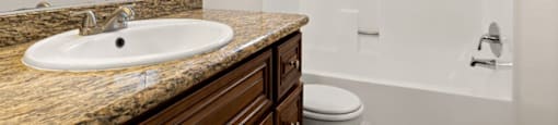 A bathroom with a sink, toilet, and bathtub.