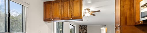 A kitchen with wooden cabinets and a stainless steel dishwasher.