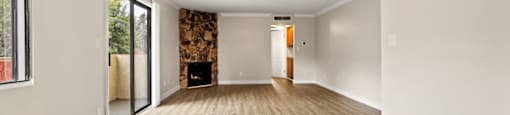 A room with a fireplace and wood flooring.