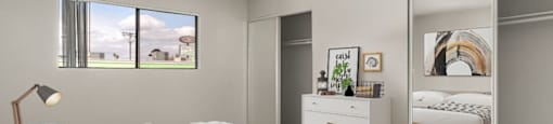 A bedroom with a large bed and a dresser with a mirror.