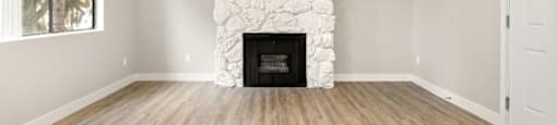 A room with a fireplace and wooden floors.
