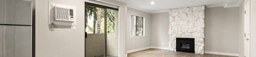 A spacious living room with wood flooring and a fireplace.
