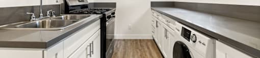 A modern kitchen with white cabinets and stainless steel appliances.