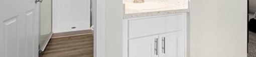 A bathroom with a white door and a white counter. at The Meadows at Westlake Village Apartments,Westlake Village, California