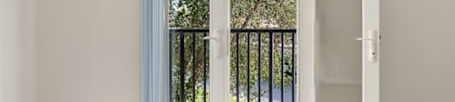A room with a white door and a balcony with a black railing.