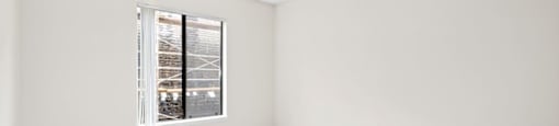 a bedroom with a large window at Woodland Trio Apartments, North Hollywood, California