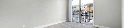a bedroom with a sliding glass door and a carpeted floor