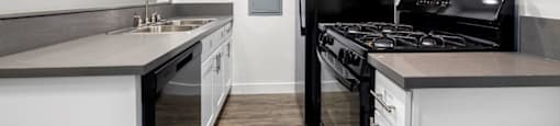 a kitchen with white cabinets and black appliances