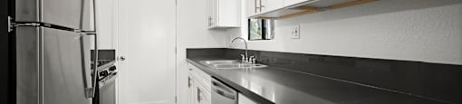 Apartments in Sherman Oaks for Rent - Brody Terrace - Modern Kitchen with Stainless Steel Appliances, Black Counter Tops & White Cabinets