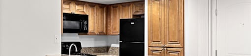 a kitchen with a counter top and a refrigerator at Woodland Trio Apartments, North Hollywood, CA