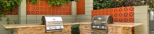 Apartments For Rent In Encino CA - White Oak Terrace - Exterior View Of Community Barbecue Grills Featuring Two Stainless Steel Built-In Grills on Rough Stone Outdoor Kitchen Counters