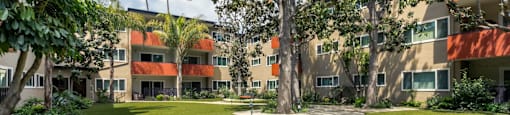 Apartments for Rent in Encino, CA - White Oak Terrace - Manicured Lawn, Palm Trees, and Exterior of the Apartment Complex