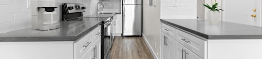 a white kitchen with white cabinets and black counter tops