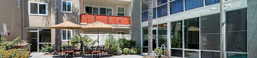 Sherman Oaks Apartments - Krystal Terrace - Pool with Umbrella Covered Seating Area, Plants, and View of Apartment Complex