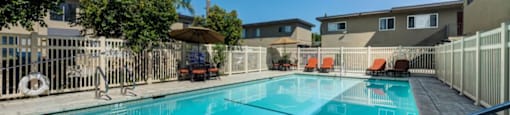 Canoga Park Luxury Apartments - Large Swimming Pool Surrounded by Lounge Chairs and Tables
