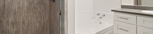 a bathroom with a shower and a sink and a bath tub at Parkway Plaza Apartments, Culver City, CA