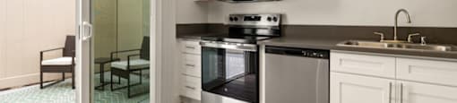 a kitchen with stainless steel appliances and a sliding glass door at Parkway Plaza Apartments, Culver City, CA