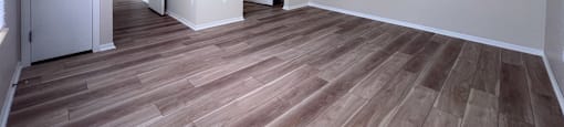 A room with wooden flooring and white walls.