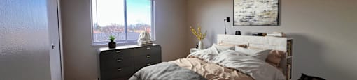 a bedroom with a bed and a window at Huntington Green Apartments, University Heights, 44118