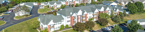 A large building with a parking lot in front of it. at Highlands of Heritage Woods Apartments, Copley, OH