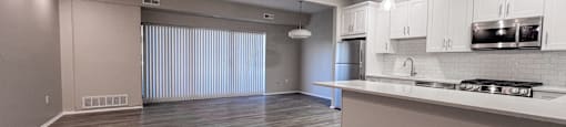 an empty living room and kitchen with white cabinets at Huntington Green Apartments, University Heights, 44118