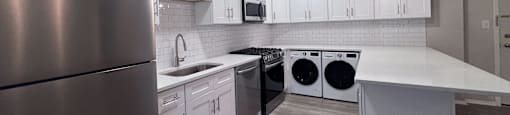 a kitchen with white cabinets and stainless steel appliances at Huntington Green Apartments, University Heights, OH