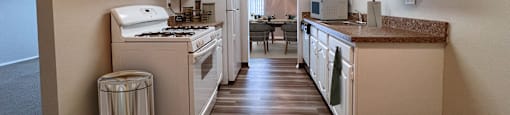 a kitchen with white appliances and white cabinets and a vinyl floor at Huntington Green Apartments, University Heights, Ohio