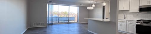 an empty living room and kitchen with wood flooring at Huntington Green Apartments, University Heights, Ohio