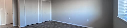an empty living room with wood floors and white walls at Huntington Green Apartments, University Heights, Ohio