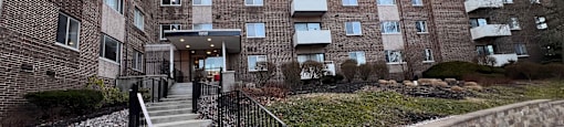 a large brick building with stairs in front of it at Huntington Green Apartments, University Heights, Ohio