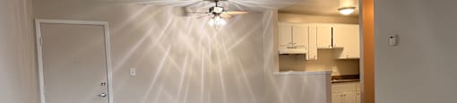 A room with a ceiling fan and carpeted floor.