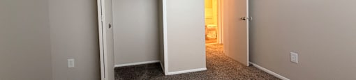 A room with a carpeted floor and a white door.