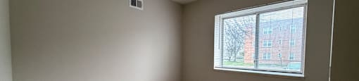A room with a window and wooden flooring.