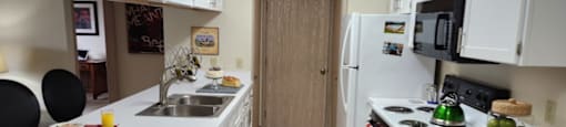 A kitchen with white cabinets and a tiled floor.at Highlands of Heritage Woods, Copley, OH 44321