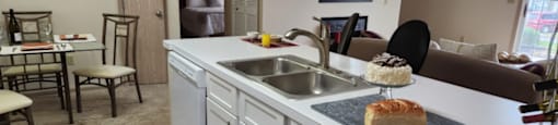 A kitchen with a sink, a cake on a plate, and a chair.at Highlands of Heritage Woods, Ohio, 44321