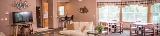 A living room with a television, couches, and a ceiling fan.at Highlands of Heritage Woods, Copley Ohio