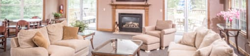 A living room with a fireplace and a ceiling fan.at Highlands of Heritage Woods, Copley