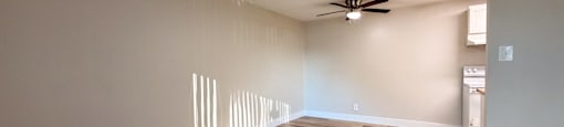A room with wooden flooring and a ceiling fan.