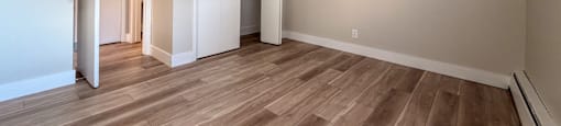 A room with wooden flooring and white walls.