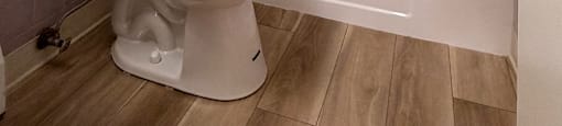 A white toilet and bathtub in a bathroom with purple tiles.
