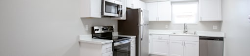an empty kitchen with white cabinets and stainless steel appliances at Ascent on Peoria Apartments, Arizona, 85029